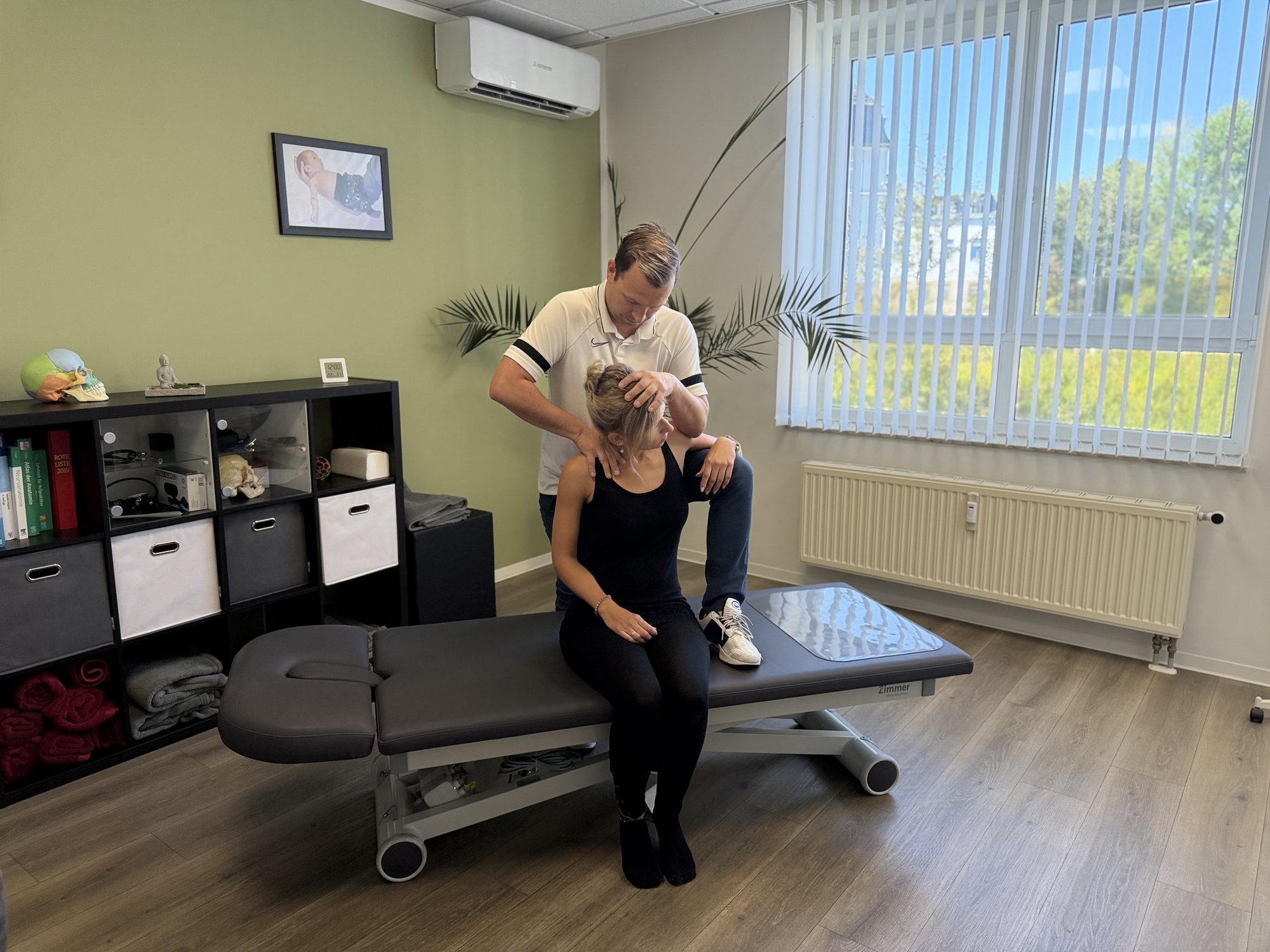 Christoph Uhlmann behandelt die Halswirbelsäule einer Patientin in seiner Praxis in Limbach-Oberfrohna